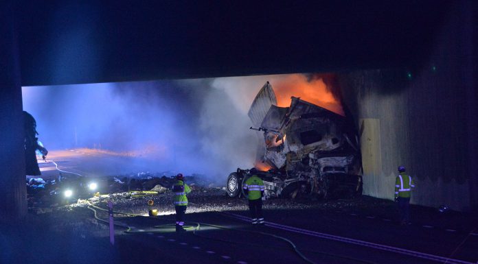Lastbil tog eld efter krasch mot betongvägg